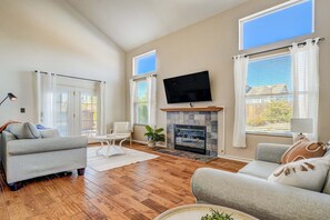 A living room with a fireplace, a flat-screen TV, and a sofa. - 4286 Morning Glory (Colorado Springs)