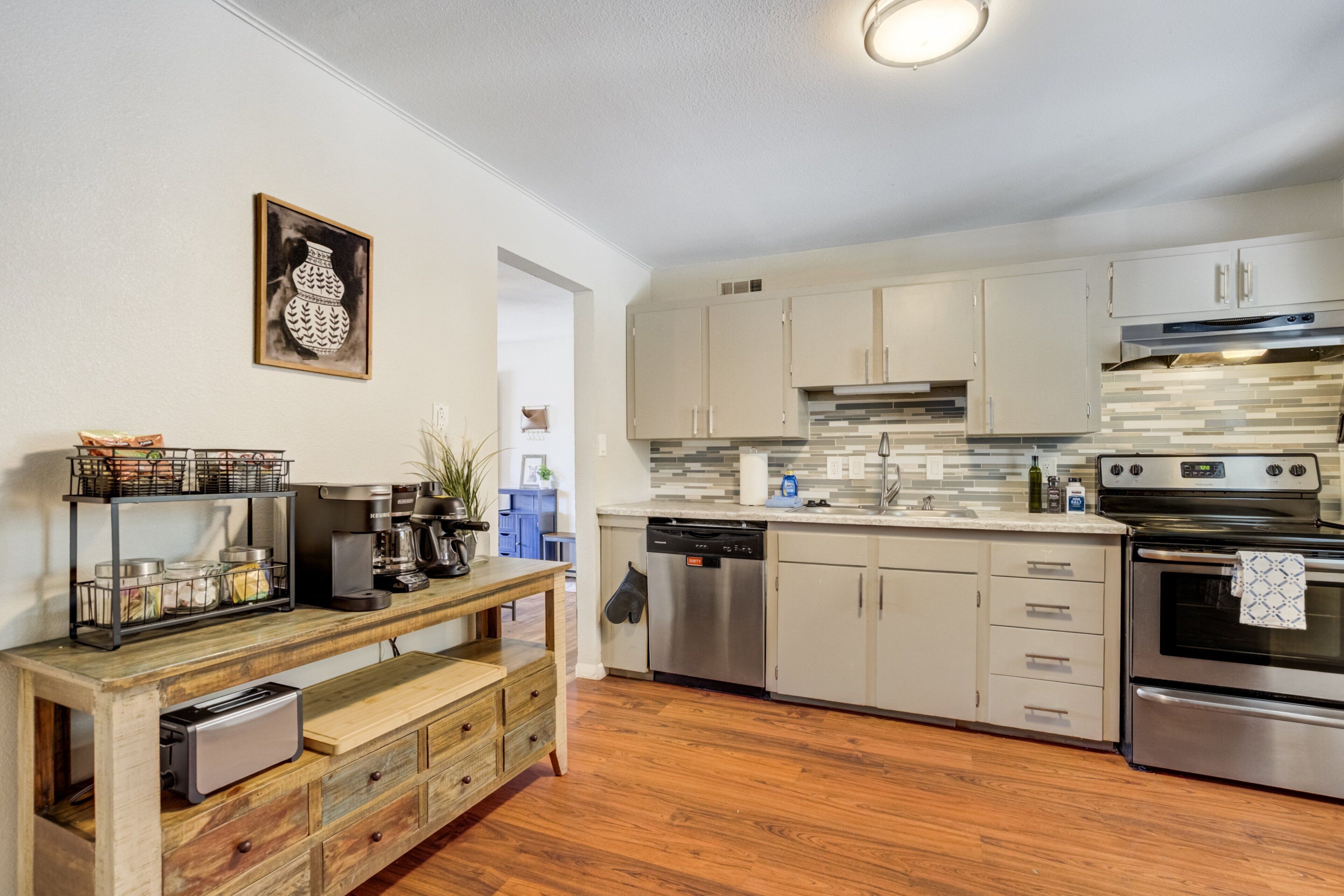 Una cocina moderna con armarios de madera, lavavajillas integrado y horno de acero inoxidable.