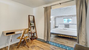 Un dormitorio con cama, escritorio y silla.