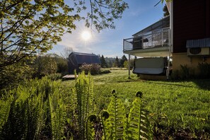 A residential property with a fenced yard, a wooden barn, and a two-story house with a balcony.
