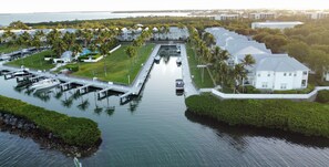 An aerial view of a waterfront property with a marina, multiple white buildings, and lush greenery. - Waterfront Luxury Villa With Sunset Views and Boat Slip (Marathon)