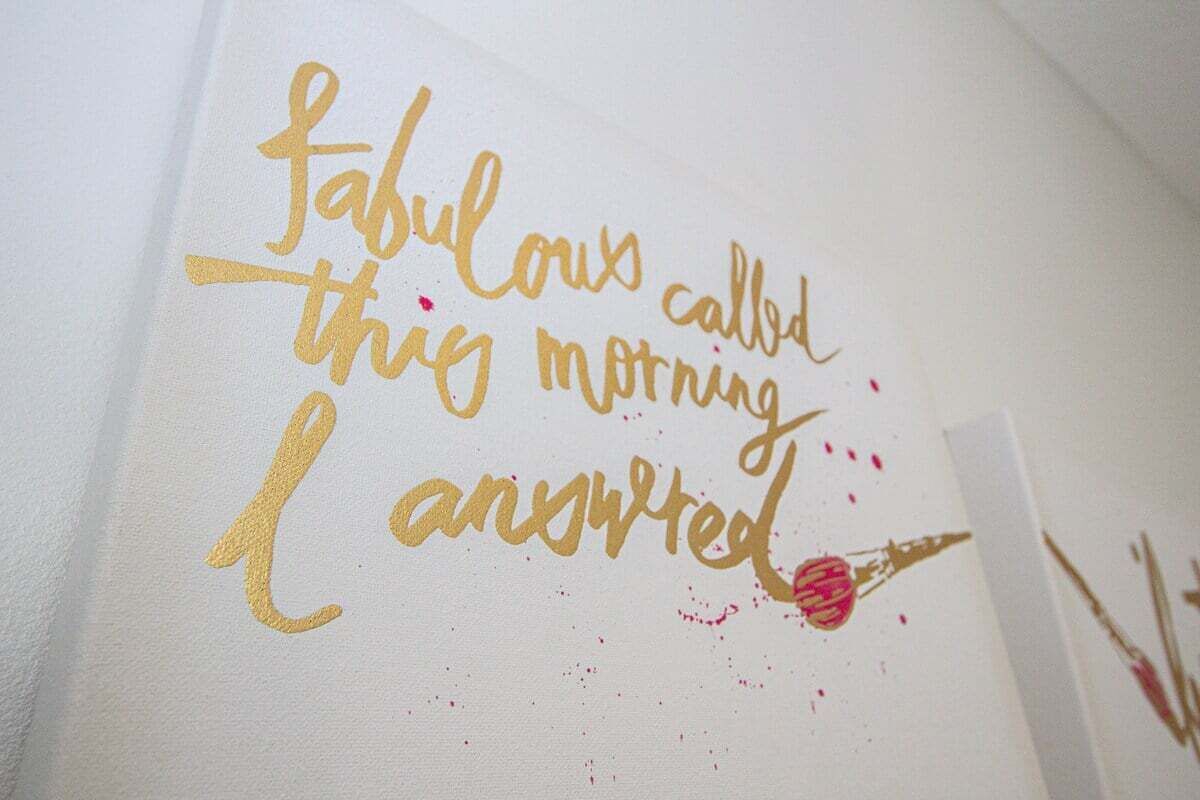 A wall with the text "fabulous called this morning I answered" in gold lettering.