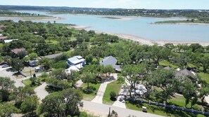 An aerial view of a residential area with houses, trees, and a large body of water in the background. - Lakeshore Escapes, on Canyon Lake Waterfront (Canyon Lake)