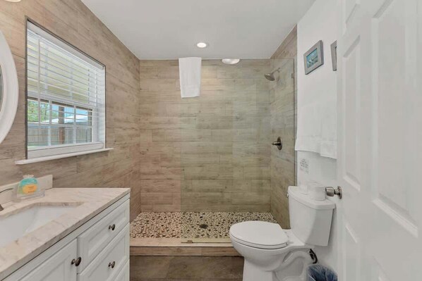 A bathroom with a shower, toilet, and vanity. - Lakeshore Escapes, on Canyon Lake Waterfront (Canyon Lake)