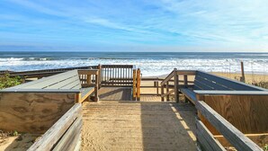A wooden boardwalk leading to a beach with a wooden bench and a sign indicating a short distance to the beach. - Anderson's Tranquility - Classic Oceanfront 3 BR Cottage in Southern Shores (Southern Shores)