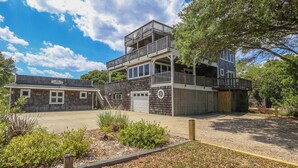 En toetagers bygning med balkon, garage og overdækket område.