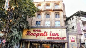 Hotel Roopali Inn Restaurant with a traditional facade, a visible entrance, and parked vehicles in front. - Hotel Roopali (Jabalpur)