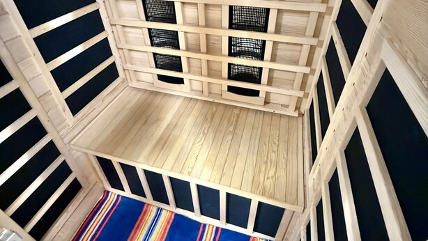 A wooden interior with a sloped ceiling and a colorful striped rug on the floor. - Beautiful home in Burlington's South End, humans and dogs welcome! (Burlington)