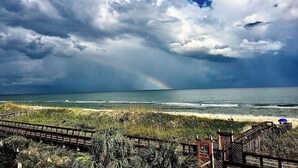 A beach with a wooden boardwalk and a view of the ocean. - Oceanfront Comfort at the Cabana! (Carolina Beach)