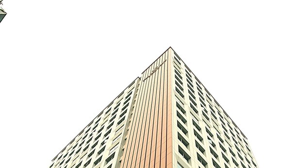 Un edificio alto dal design moderno, con una sezione verticale ben visibile di colore marrone rossastro.