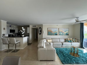 A modern living room with a sofa, a coffee table, and a dining area with a kitchen in the background. - THE COASTAL ! GREAT 2BD 2BA APT WITH STUNNING VIEWS AT AVENTURA YACHT CLUB ! (Aventura)