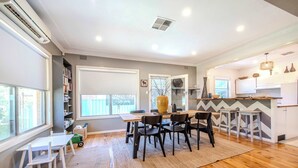 Une cuisine moderne avec un plancher en bois, un coin repas avec une table et des chaises, et une grande fenêtre.