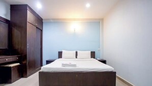 Un dormitorio con una cama grande, un armario y una mesita de noche.