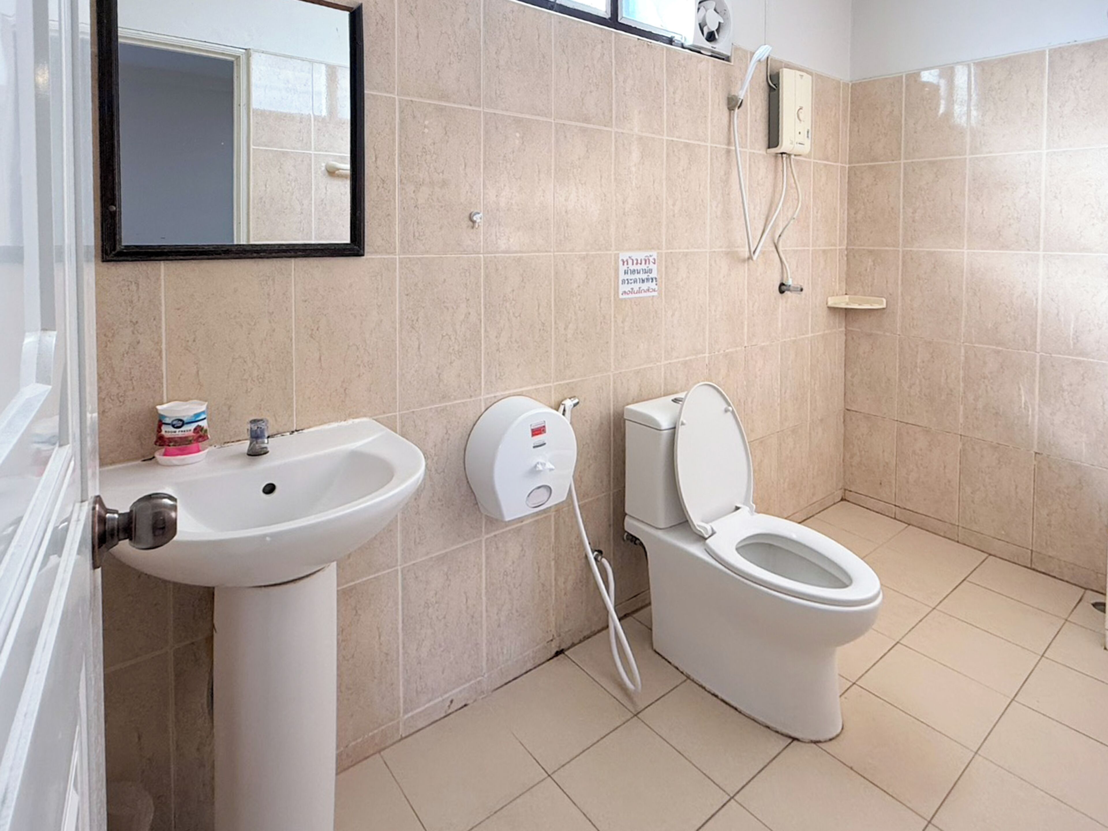A modern bathroom with a sink, toilet, and a hand dryer.