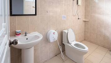 A modern bathroom with a sink, toilet, and a hand dryer.