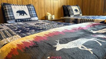 A bed with a patterned blanket and two pillows with animal designs.