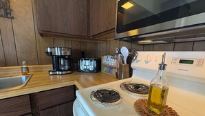 Eine Küche mit einem weißen Herd, einer Kaffeemaschine, einem Toaster und Holzschränken.