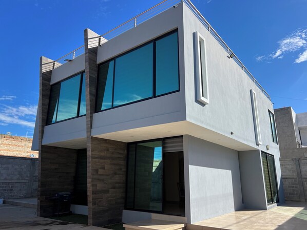 A modern two-story building with large windows and a flat roof.
