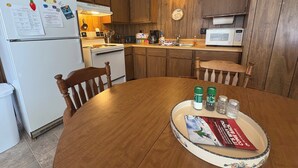 Una cocina con armarios de madera, un refrigerador blanco, una estufa y un microondas.