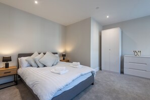 A modern bedroom with a large bed, bedside tables with lamps, a wardrobe, and a neutral color scheme. - Central 1BR Flat Near Old Town and Hull College (Kingston upon Hull)