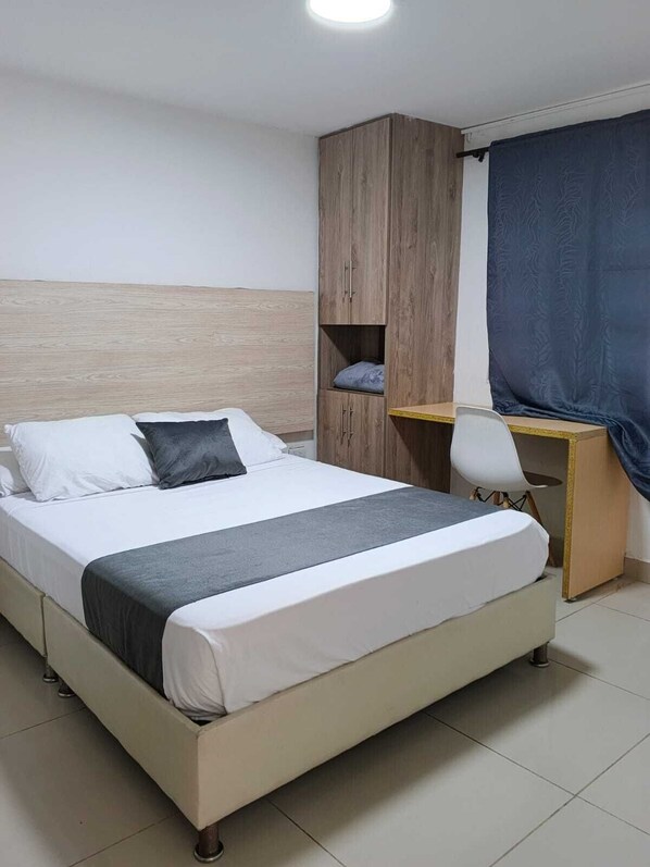 Une chambre à coucher avec un lit, un bureau et une chaise.
