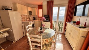 Una cocina compacta con comedor, lavadora y balcón con vistas.