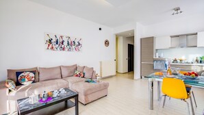 Ein modernes Wohnzimmer mit einer Couch, einem Couchtisch und einem Essbereich mit Stuhl und Tisch.