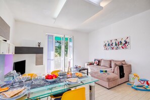 Un salon moderne avec une table à manger en verre, un canapé et un cheval à bascule coloré pour enfants.