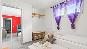 A modern living room with a sofa, a wooden cabinet, and a dining area visible through an open door. - Locarno Centro Apartment 2BR With Private Garage (Locarno)