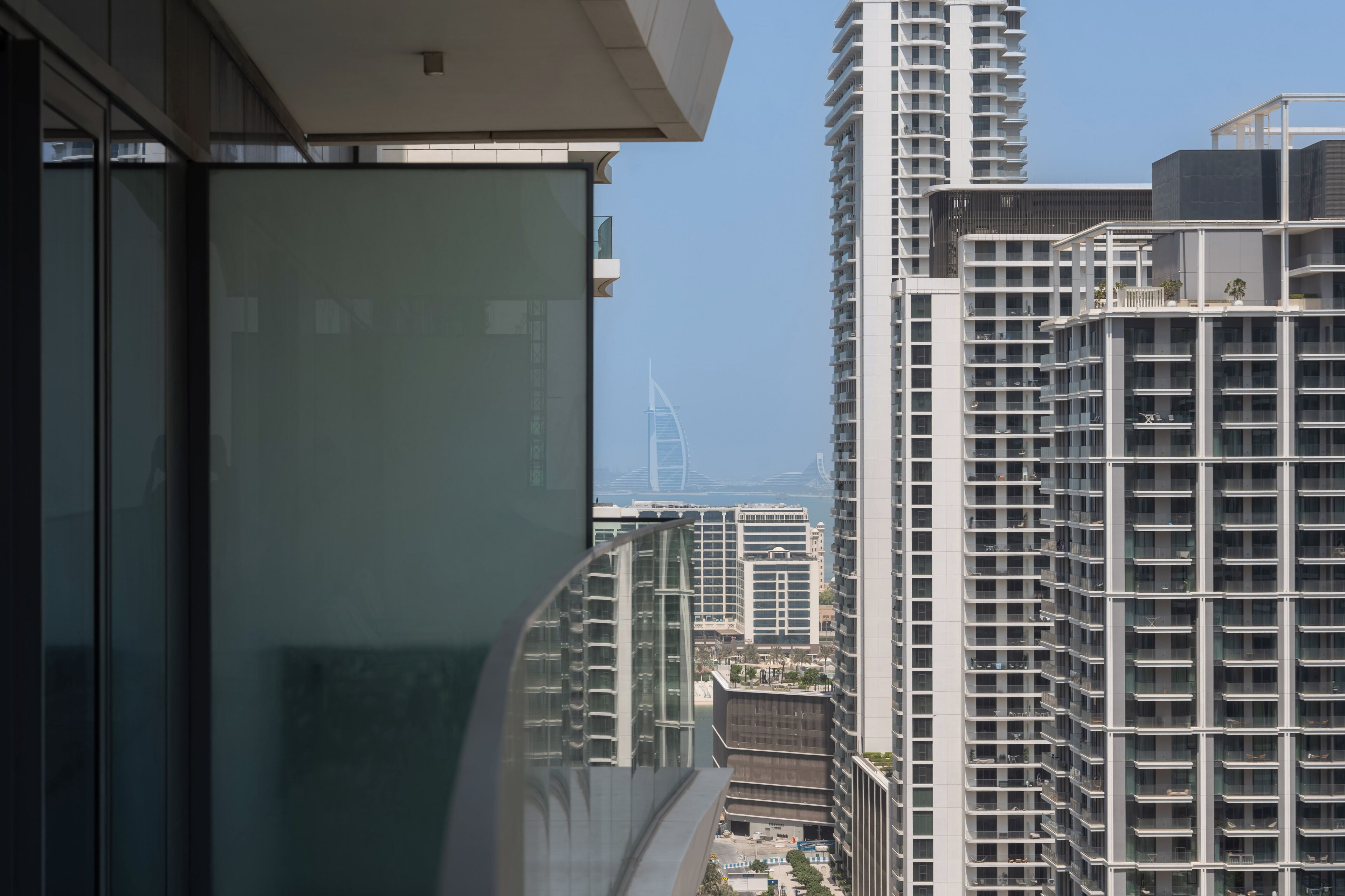 Ein Hochhaus mit moderner Architektur, das mehrere Balkone und einen klaren Blick auf die Stadtkulisse im Hintergrund bietet.