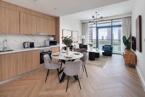 A modern apartment with a kitchen, dining area, and living room. - Beachfront Marina Skyline Views (Dubai)
