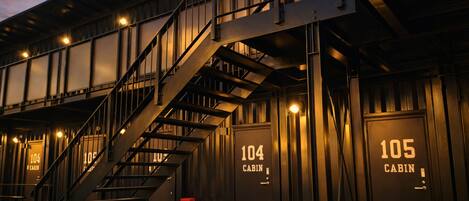 A building with a staircase leading to multiple cabins, each labeled with a number.