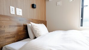 A neatly made bed with white linens, a wooden headboard, and a wall-mounted light switch. - Hotel Cradle Cabin TANASHI (Nishitokyo)