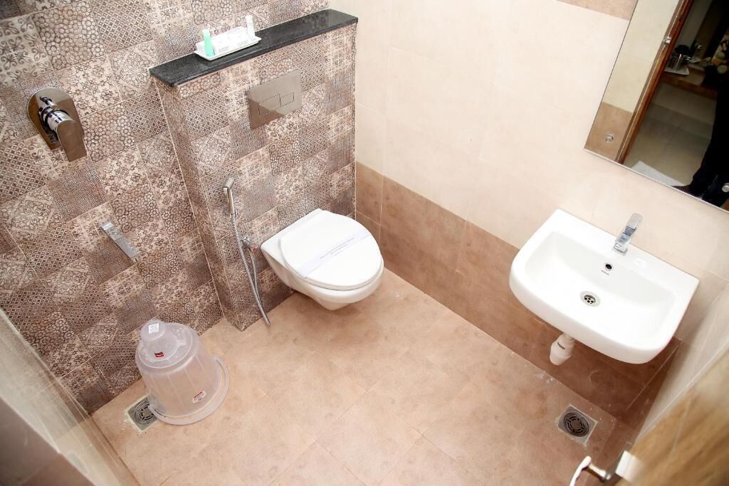A bathroom with a toilet, sink, and shower.