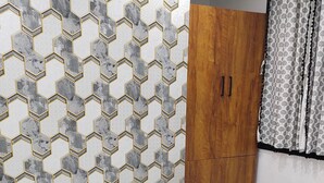 Un dormitorio con cama, armario de madera y mesita de noche con control remoto.