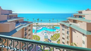 A resort with a central pool, multiple balconies, and a view of the sea. - Seaside Serenity at Sonoran Spa N704 (Puerto Peñasco)