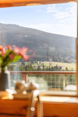 A room with a view of a mountainous landscape, a wooden table, and a potted plant. - Log Cabin Retreat on Peaceful 5 Acres with Epic Views (Bell Hill)