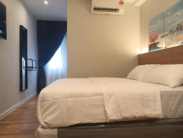 Camera d'albergo con un letto grande, una testiera in legno, un condizionatore d'aria, un quadro appeso al muro e una finestra con tende.