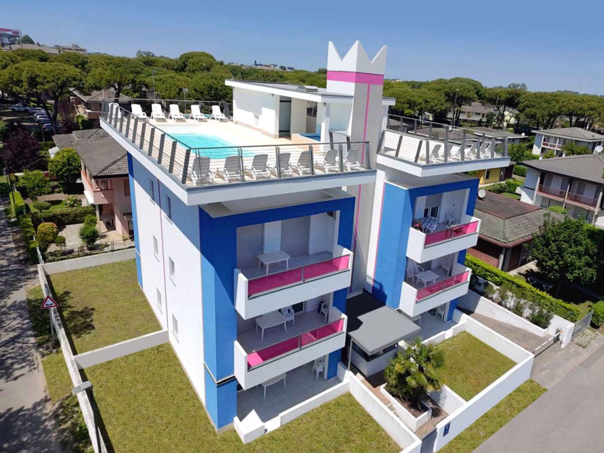 Un edificio moderno con piscina en la azotea y varios balcones.