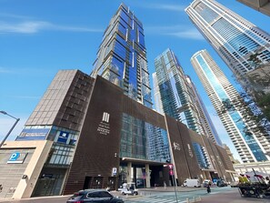 A modern building with a prominent entrance and multiple high-rise buildings in the background. - Deluxe Marina Gate Suite w/ Sea & Ain Dubai View (Dubai)