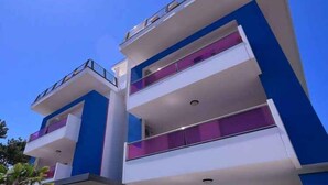 Un edificio moderno de varios pisos con balcones y cielo despejado.