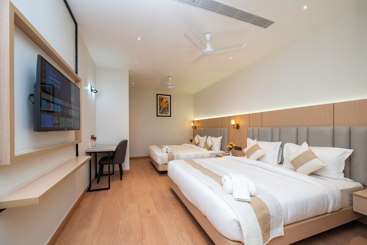 Una habitación de hotel con cama, mesita de noche y escritorio con silla.