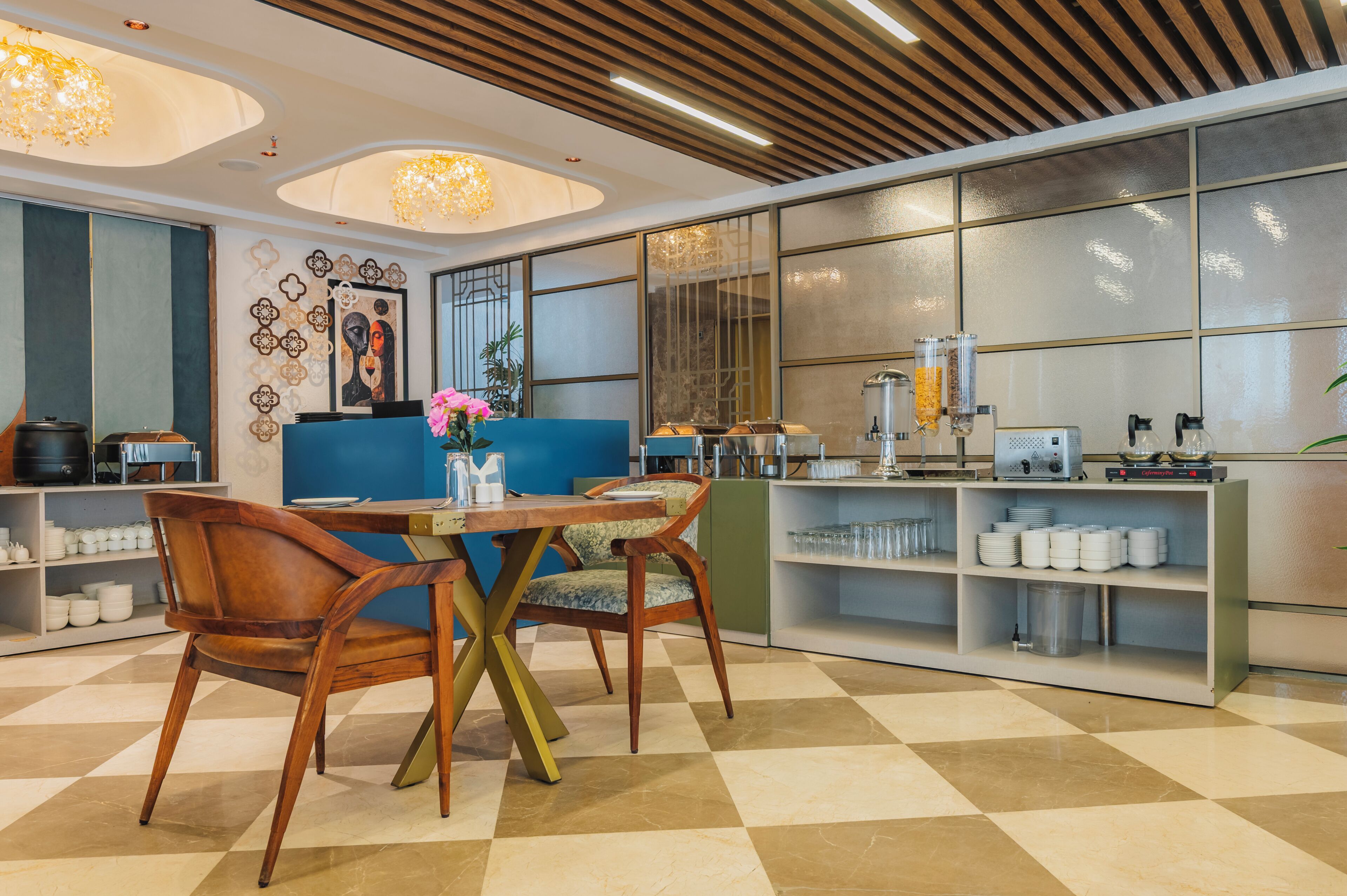 Eine moderne Hotelhalle mit einem Schachbrettmuster-Boden, Holzmöbeln, einem blauen Sofa und einer Bar mit Gläsern.
