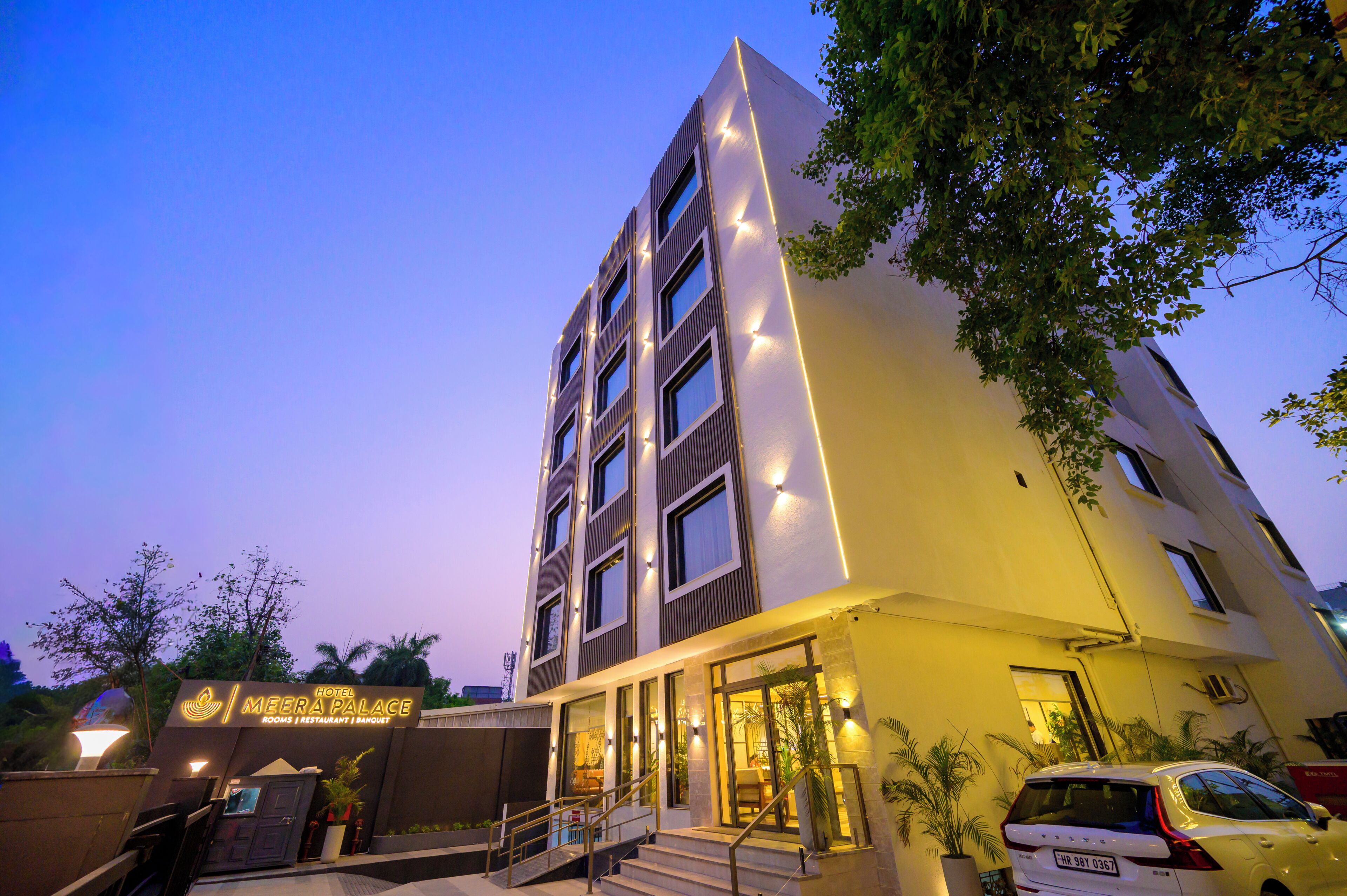A modern hotel with a prominent entrance, multiple floors, and a well-lit facade.