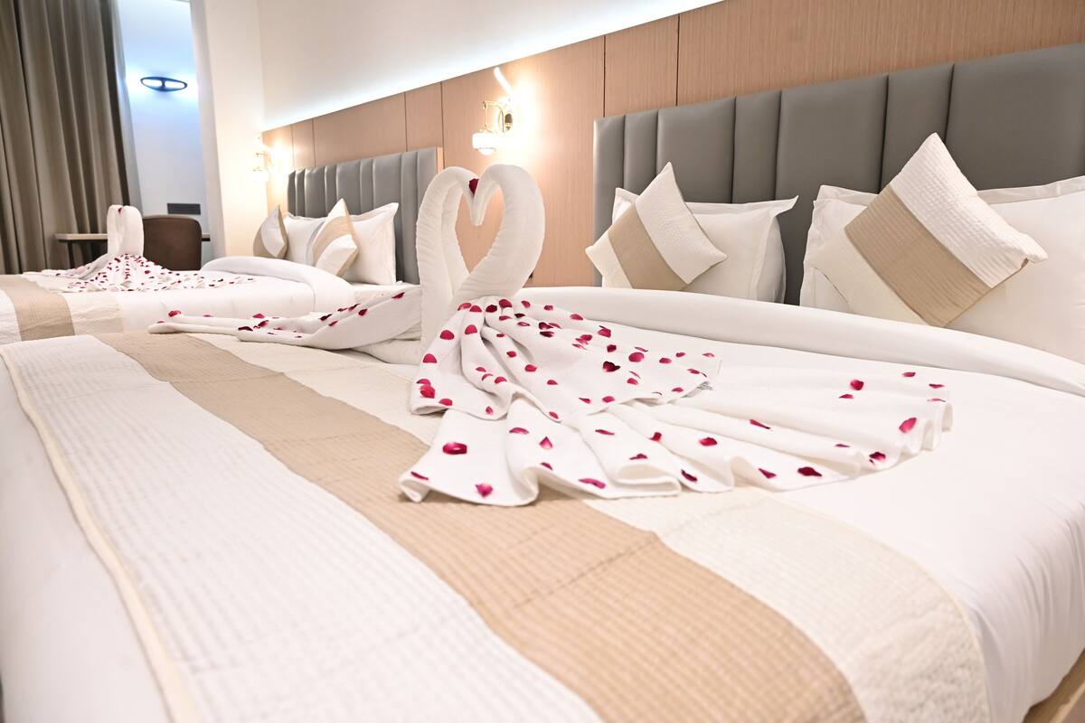 A hotel room with a large bed, a headboard, and a bedside table.