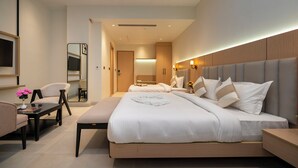 Una habitación de hotel moderna con una cama grande, un escritorio, una silla y un televisor.