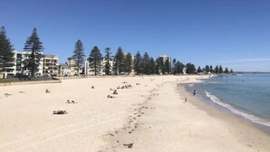 A beach with buildings and trees in the background. - Stylish 2-Bed with Terrace, 3-min Walk to Beach (Glenelg)