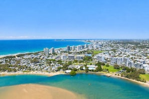 A coastal cityscape with high-rise buildings, a beach, and a clear blue sky. - 2 Bedford Court - 15 Cotton Tree Parade (Sunshine Coast)