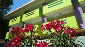 A modern building with a flat roof and a series of balconies. - Holiday apartment with air conditioning, balcony and pool (Bibione)
