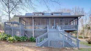 A two-story building with a covered outdoor area and a staircase leading to the upper level. - Fish & Swim Off the Dock: Lake Sinclair Family Gem (Eatonton)